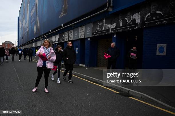 Members of the 1878s, Everton's supporter group, distribute leaflets reading "Corrupt" next to the Premier League logo, to protest over the club...