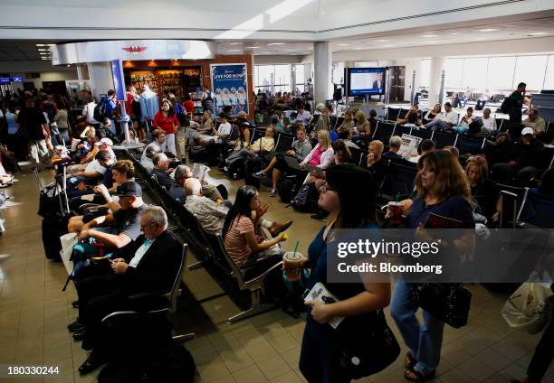 Travelers wait for flights in Terminal One at Los Angeles International Airport in Los Angeles, California, U.S., on Friday, Sept. 6, 2013. Yields on...