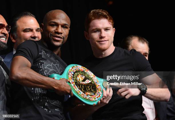 Boxers Floyd Mayweather Jr. And Canelo Alvarez hold a WBC super welterweight championship belt during the final news conference for their bout at the...