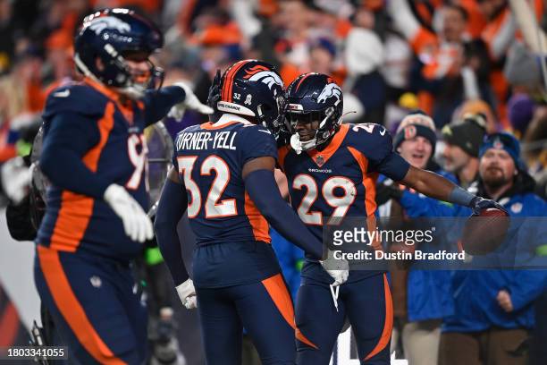 Cornerback Ja'Quan McMillian of the Denver Broncos celebrates with Delarrin Turner-Yell afer an interception during the fourth quarter of the NFL...