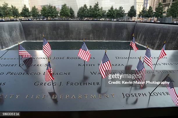 Flags adorn the 9/11 Memorial on the twelfth anniversary of the terrorist attacks on lower Manhattan at the World Trade Center site on September 11,...