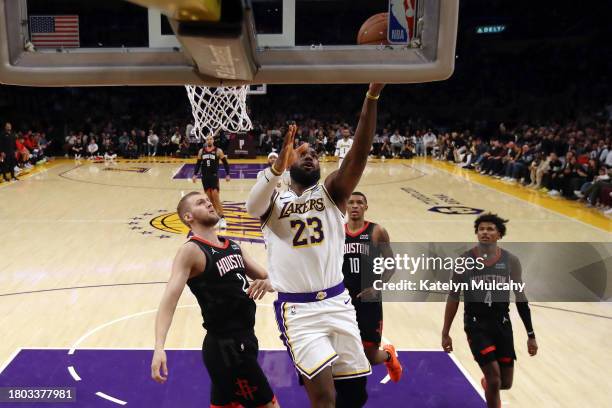 LeBron James of the Los Angeles Lakers makes a layup against Jock Landale, Jabari Smith Jr. #10 and Jalen Green of the Houston Rockets during the...