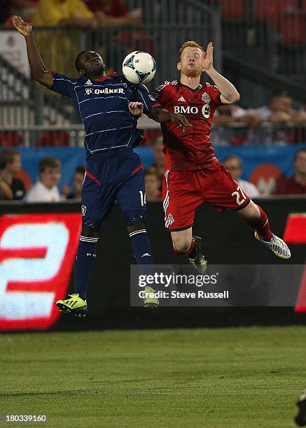 Toronto FC defender Richard Eckersley and Chicago Fire forward Patrick Nyarko jump for a ball in first half action as Toronto FC plays Chicago Fire...