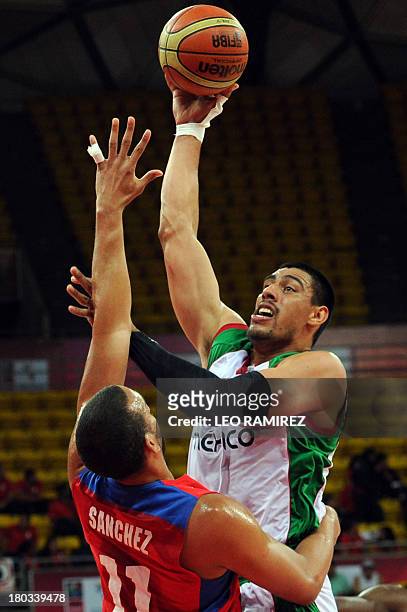 Mexican basketball player Gustavo Ayon vies for the ball with Puerto Rican Ricardo Sanchez during their FIBA Championship final game held in Caracas...
