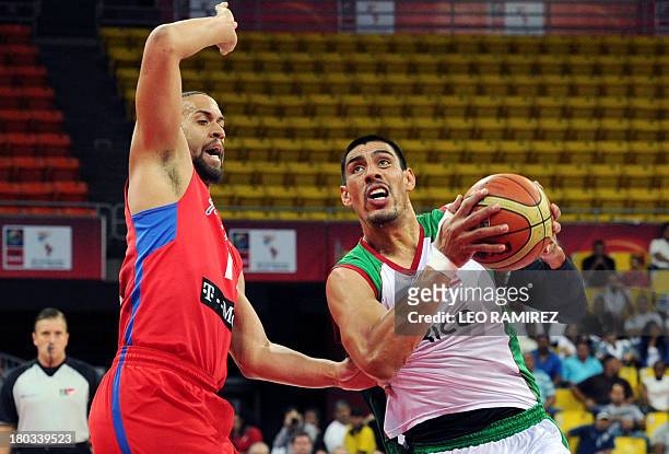 Mexican basketball player Gustavo Ayon vies for the ball with Puerto Rican Ricardo Sanchez during their FIBA Championship final game held in Caracas...