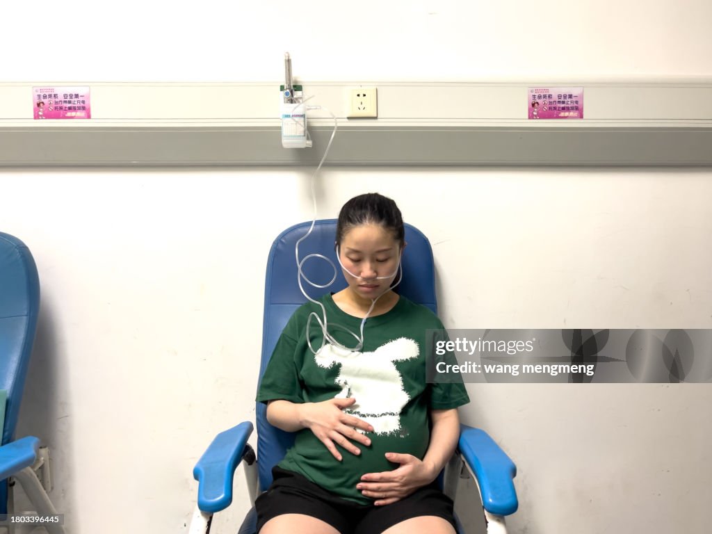 A pregnant woman in the third trimester of pregnancy is receiving oxygen