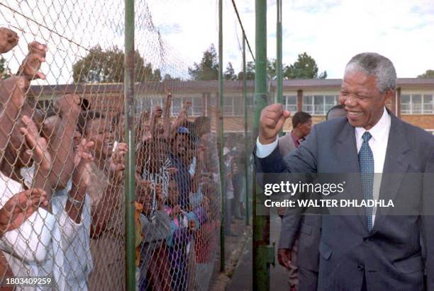 African National Congress President Nelson Mandela greets supporters behind the fence in a mining town of Randfontein west of Johannesburg 25...