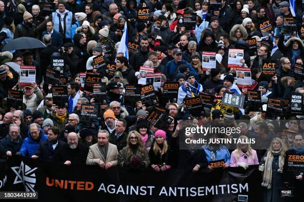 Protesters holding placards take part in a demonstration in central London, on November 26 to protest against antisemitism.