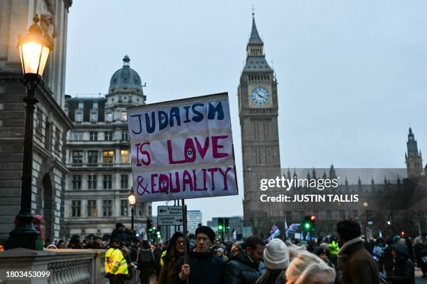 Protesters hold placards in front of Elizabeth Tower, commonly known as Big Ben, at the Houses of Parliament, in central London on November 26, 2023...