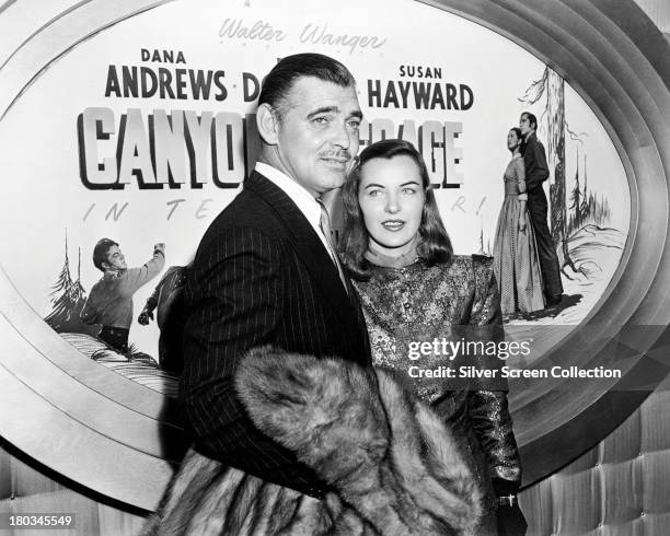 American actors Clark Gable and Ella Raines at the premiere of Jacques Tourneur's 'Canyon Passage', USA, July 1946. Behind them is a poster for the...