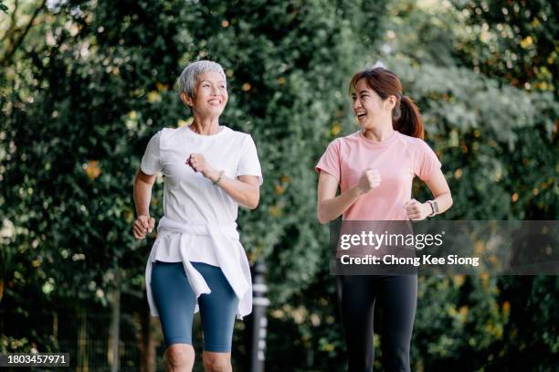 madre e hija chinas asiáticas trotando juntas. - madre-corriendo fotografías e imágenes de stock
