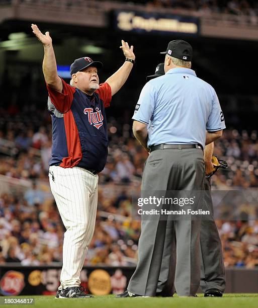 Ron Gardenhire of the Minnesota Twins speaks with umpires Dale Scott and Bill Miller during the fourth inning of the game against the Oakland...
