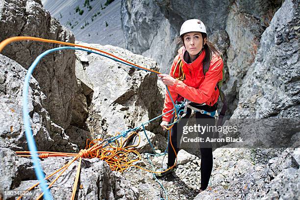 women feeding out rope while climbing a mountain - climbing rope stock-fotos und bilder