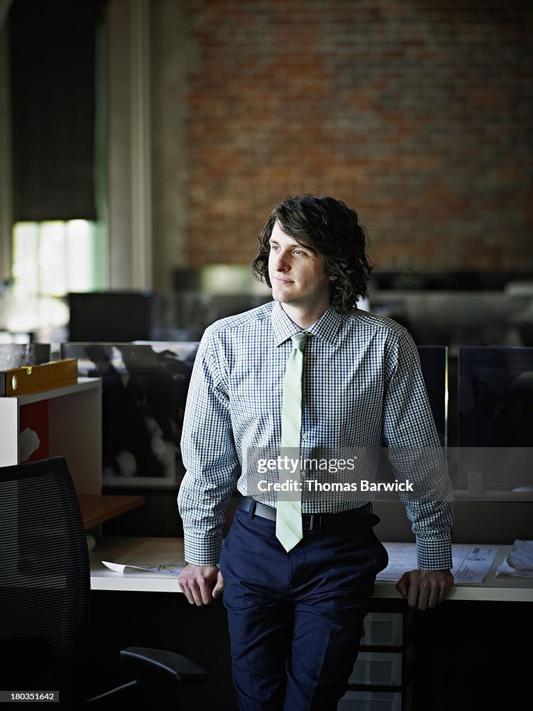 Businessman leaning against desk in office