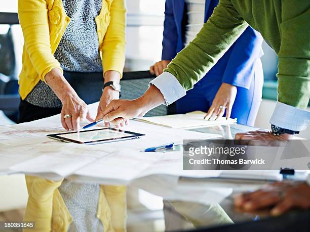 coworkers discussing project on digital tablet - strategy stock pictures, royalty-free photos & images