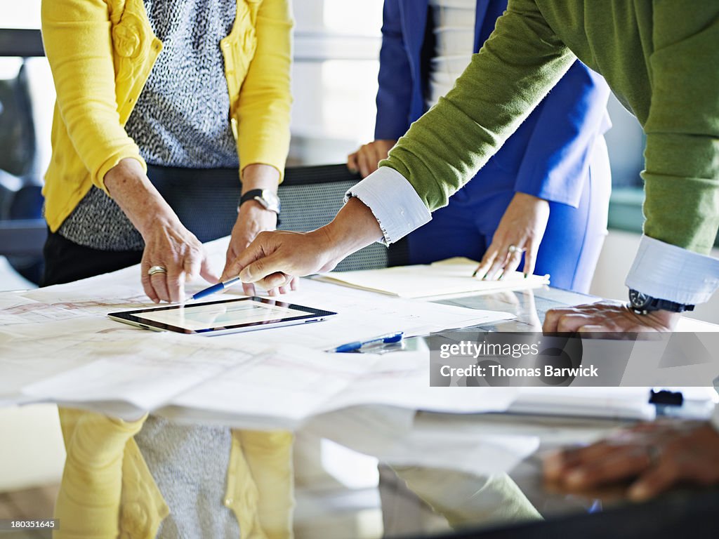 Coworkers discussing project on digital tablet