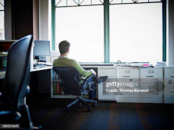 businessman sitting in chair at desk rear view - leaning stock pictures, royalty-free photos & images