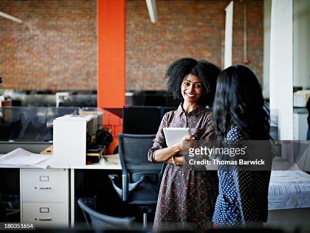 coworkers in discussion in office - leanincollection stock pictures, royalty-free photos & images