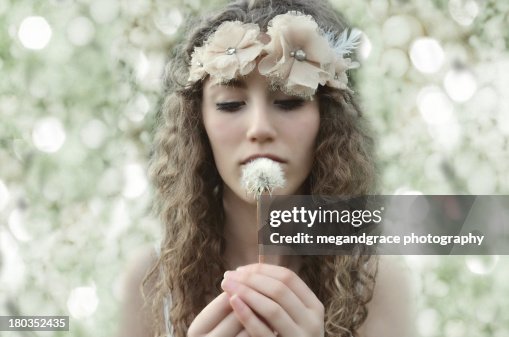 Girl with curly hair holding dandelion clock Girl with curly hair holding dandelion clock