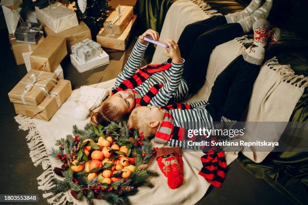 children relaxing on the sofa using smartphone christmas holidays - 2 5 months 個照片及圖片檔