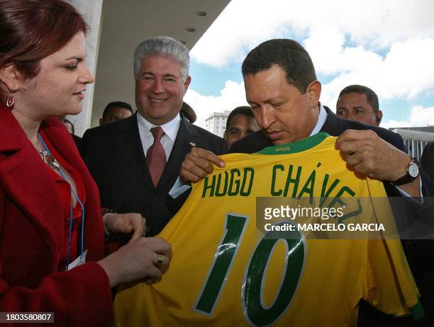 El presidente de Venezuela Hugo Chávez recibe una camiseta del seleccionado de fútbol de Brasil con su nombre, acompañado por el gobernador del...