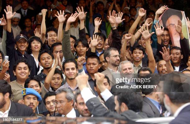 Supporters of Iranian President Mahmoud Ahmadinejad wave their hands to say goodbye as the president leaves the Islam University of Syarif...
