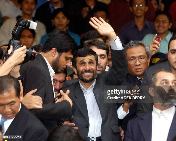 Iranian President Mahmoud Ahmadinejad waves to students as he leaves the Islam University of Syarif Hidayatullah in Tangerang 11 May 2006....