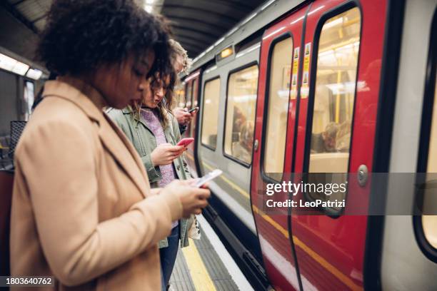people waiting for the subway texting on mobile - metro de londres imagens e fotografias de stock