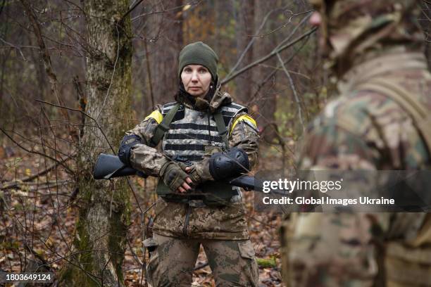 Woman in military uniform and with an automatic rifle in her hands stands during an exercise on November 11, 2023 in Kyiv, Ukraine. Fighters of the...