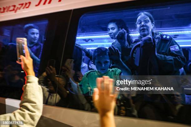 Hostages released by Hamas Gal and Tal Almog-Goldstein stand in a bus transporting them to an army base in Ofakim in southern Israel after they were...