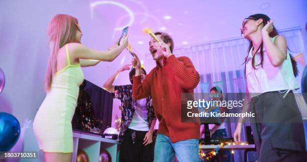 group of young diverse millennial asian friends with lgbtqia+ people dance together at home party, celebrate new year, christmas, or birthday at night. happy celebration event, fun activity concept - youtube tiktok stock pictures, royalty-free photos & images