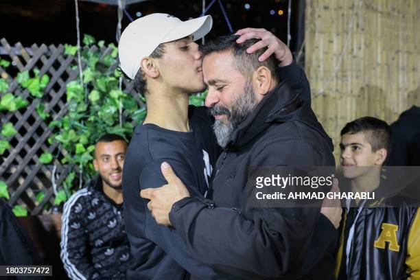 Palestinian Mohammed Al-Awar , former prisoner released from an Israeli jail in exchange for hostages freed by Hamas in Gaza, kisses his father's...