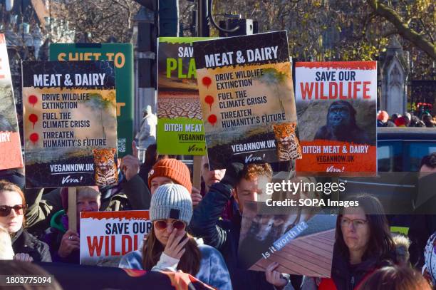 Protesters hold placards describing the dangers posed by meat and dairy to the environment, climate and wildlife, during the demonstration. Vegan...
