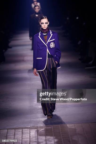 Model walks the runway at the Dries Van Noten show during Paris Fashion Week Autumn/Winter 2016/17, she wears a purple varsity style blazer with wide...