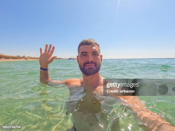 young man having a video call  in the red sea in egypt - animal waving stock pictures, royalty-free photos & images