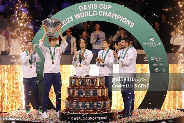 Italy's Jannik Sinner raises the trophy as he celebrates with teammates winning the Davis Cup tennis tournament after beating Australia at the Martin...