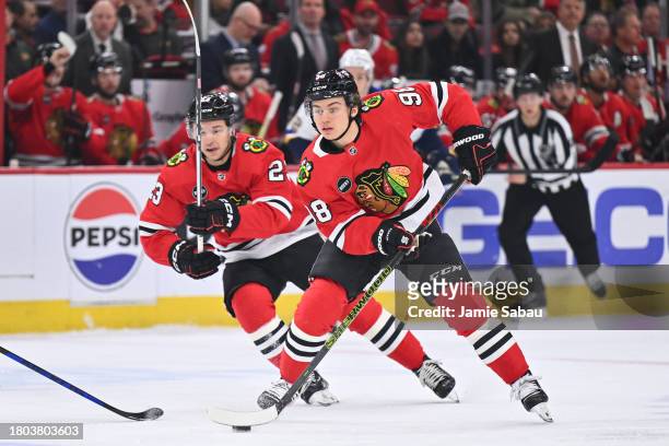Connor Bedard of the Chicago Blackhawks controls the puck as Philipp Kurashev follows in the first period against the St. Louis Blues on November 26,...