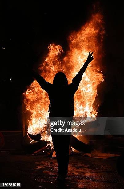 Protester flashes V sign near a fire barricade during a protest over the death of Ahmet Atakan on September 11, 2013 in Dikmen neighborhood of...