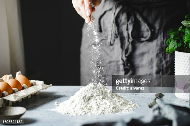 close-up of a woman preparing pasta dough in kitchen - adding salt stock pictures, royalty-free photos & images