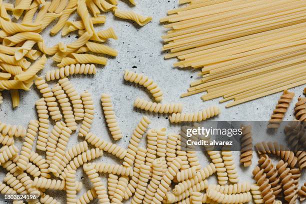 variety of types and shapes of italian pasta on marble background - dried food stock pictures, royalty-free photos & images