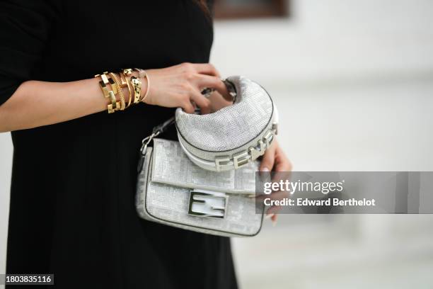 Heart Evangelista wears silver / gray shiny monogram printed Fendi bags, and golden bracelets from Cartier, during a street style fashion photo...