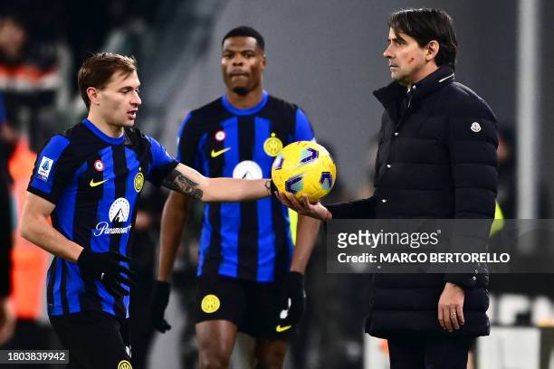 Inter Milan's Italian coach Simone Inzaghi holds out the ball to Inter Milan's Italian midfielder Nicolo Barella during the Italian Serie A football...
