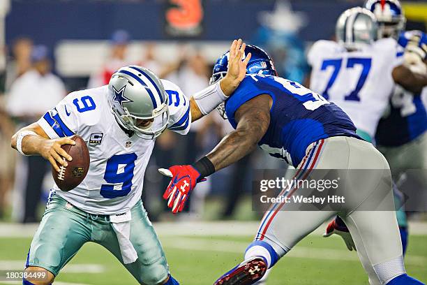 Tony Romo of the Dallas Cowboys avoids the pass rush of Mike Patterson of the New York Giants at AT&T Stadium on September 8, 2013 in Arlington,...