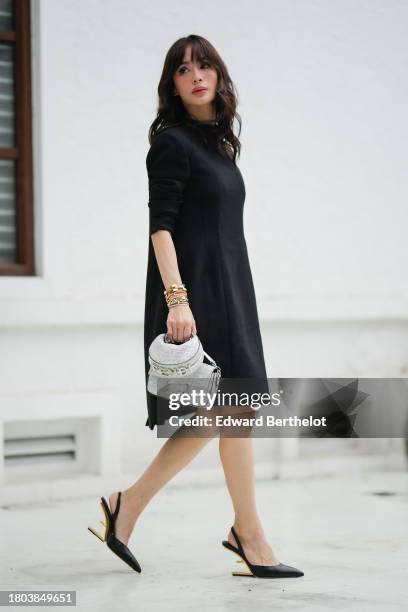 Heart Evangelista wears a Fendi full look, a black midi gathered dress with shoulder pads, Cartier golden jewelry / bracelets, gray and silver shiny...