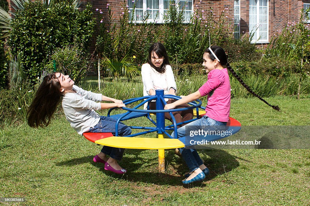 Brazilian girls playing on a merry-go-round.