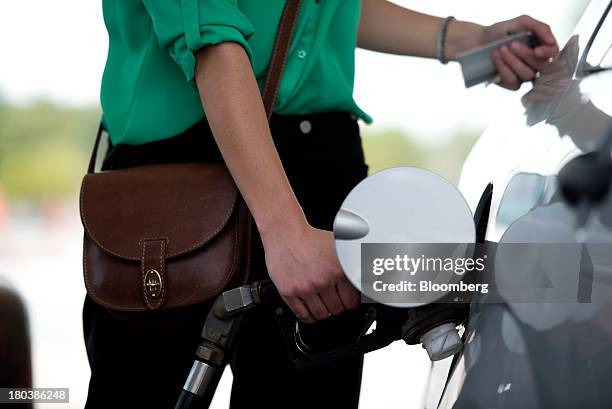 Kiley Harper fills her tank at a gas station in Peoria, Illinois, U.S., on Wednesday, Sept. 11, 2013. Gasoline climbed in New York trading as crude...