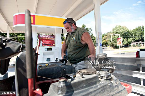 Pat McSherry, owner of Partners With Nature lawn and garden service, fills up a lawn mover at a Royal Dutch Shell Plc gas station in Peoria,...