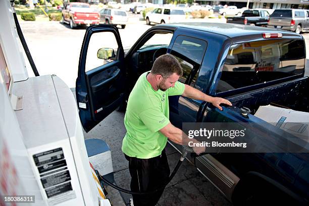 Jason Beck puts fuel in his vehicle at a gas station in Peoria, Illinois, U.S., on Wednesday, Sept. 11, 2013. Gasoline climbed in New York trading as...