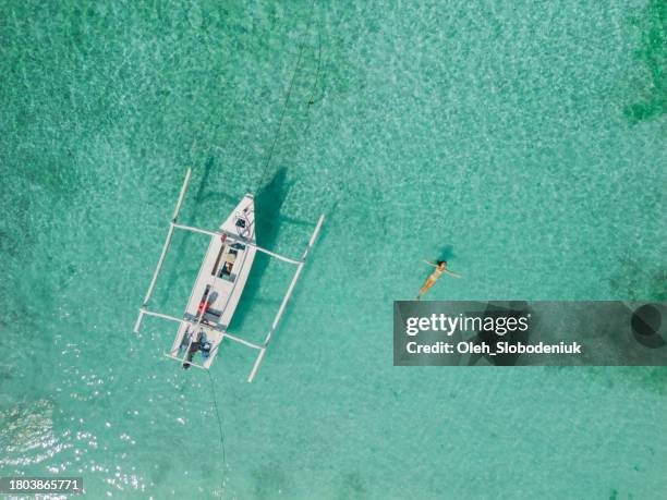 aerial view of woman swimming near perfect gili meno island - gili trawangan stock pictures, royalty-free photos & images