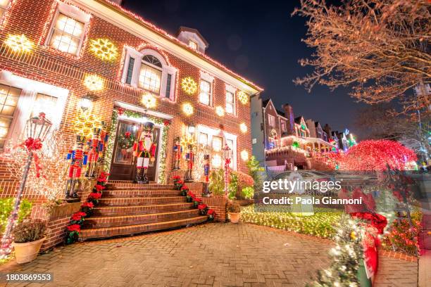 a host of christmas lights glow. unique ornaments are decorated out of the houses at dyker heights in brooklyn neighborhood - dyker heights stock pictures, royalty-free photos & images